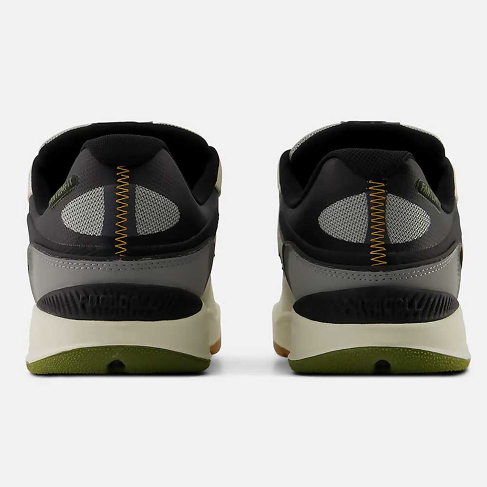 A pair of 1010 B Tiago Lemos Sea Slate Dark Olivine New Balance Numeric Suede Skateboarding Shoes is shown from the back, featuring black, gray, and olive green suede with yellow zigzag stitching and mesh accents on the heels.