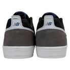 A rear view of the 306 TRI New Balance Numeric Jamie Foy Suede Shoes in Grey Black, featuring gray suede heels, white midsoles, and heel tabs with the navy blue New Balance logo—ideal for fans of quality skateboarding shoes.