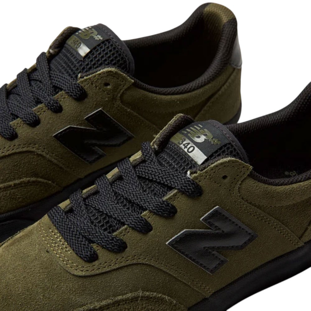 Olive green suede 340 IWT New Balance Numeric skateboarding shoes with black laces, a black N logo, a tongue tag labeled 340, and a reinforced toe cap for impact protection.