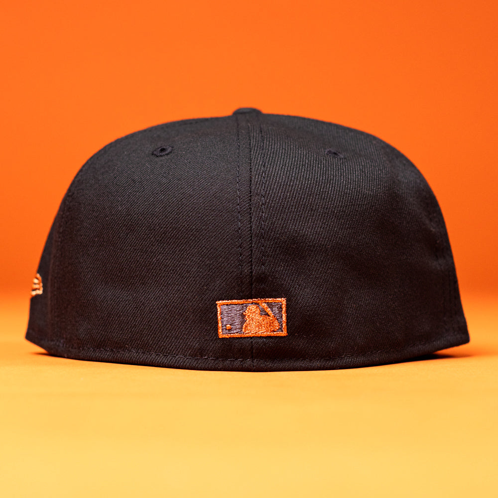 A BLVCK STAR Houston Astros New Era 5950 Fitted Hat is displayed from the back against an orange background, showcasing a small rectangular orange and blue Houston Astros logo near the bottom center.