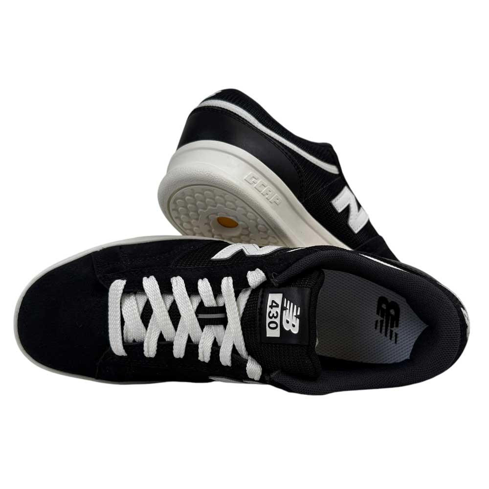A pair of 430 BWH New Balance Numeric Suede Skateboarding Shoes in black and white, featuring white laces and soles. One stands upright, showing the cushioned midsole; the other lays sideways, highlighting the top and tongue logo.