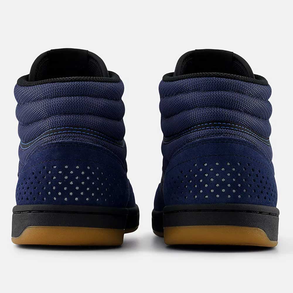A pair of Vintage Indigo Black 440 HNN New Balance Numeric Suede Skateboarding Shoes viewed from the back, featuring a textured upper, perforated suede heel panels, black midsoles, and gum rubber outsoles on a white background.