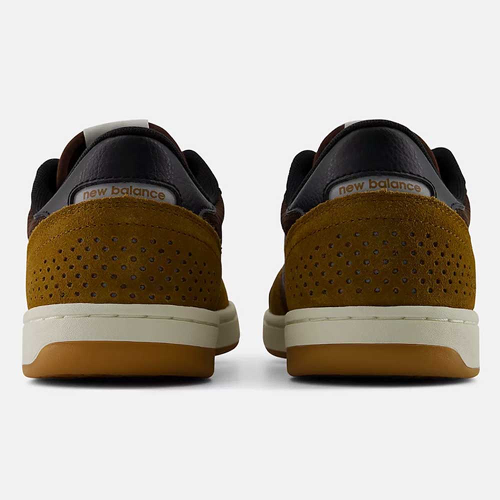 Rear view of two brown "440 PRB Pumpernickle Black New Balance Numeric Suede Skateboarding Shoes" with perforated suede heels, featuring ABZORB midsoles for superior cushioning and NDurance rubber outsoles for enhanced durability, placed side by side on a plain white background.