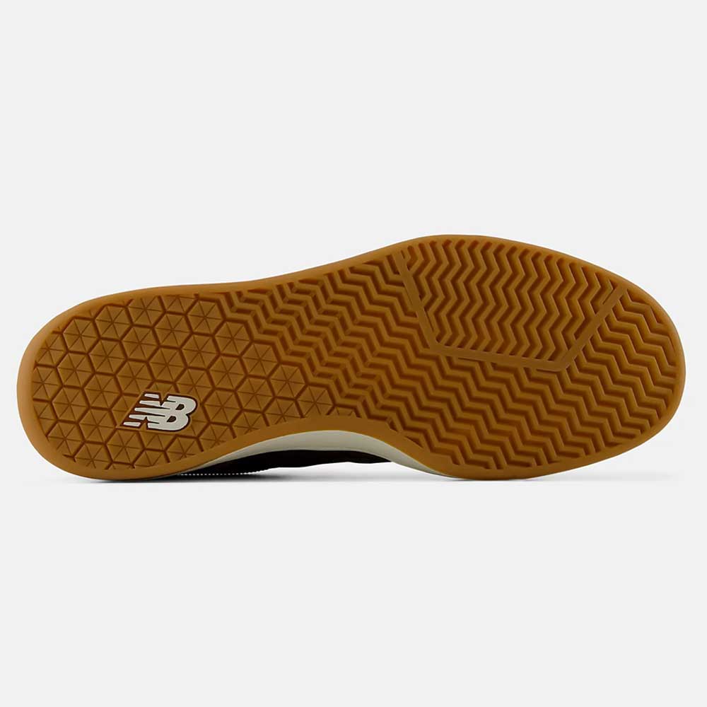 The gum sole of the 440 PRB Pumpernickle Black New Balance Numeric Suede Skateboarding Shoe is shown from below, displaying a combination of zigzag and diamond-shaped tread patterns along with a white New Balance logo on the heel. Engineered with NDurance rubber outsole technology, this skate shoe provides superior durability and grip ideal for everyday wear.
