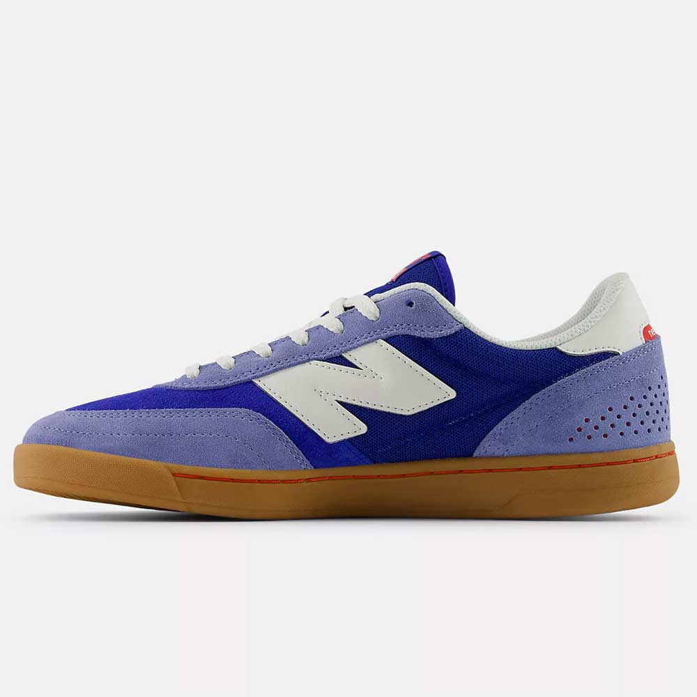 A side view of the 440 RTB Blue Gum New Balance Numeric Suede Skateboarding Shoe featuring a durable blue and purple upper, white laces and logo, suede overlays, red accents, and a light brown gum sole.