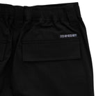 Close-up of 44643574 Groundwork Cargo Pants in black ripstop for men, featuring an elastic waistband, flat back pocket, and white "INDEPENDENT" embroidery—part of the Independent Trucks apparel collection.
