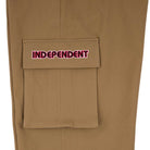 A close-up of the 44643574 Groundwork Cargo Pants in dark khaki ripstop shows a pocket with a flap, embroidered with INDEPENDENT in red and white, capturing classic cargo pants style for men.
