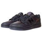 A pair of 480 BFK Bronze 56K New Balance Numeric Skateboarding Shoes in suede black iridescent, with black laces and purple-gold accents on the tongue and side logo, shown from a front-side angle.