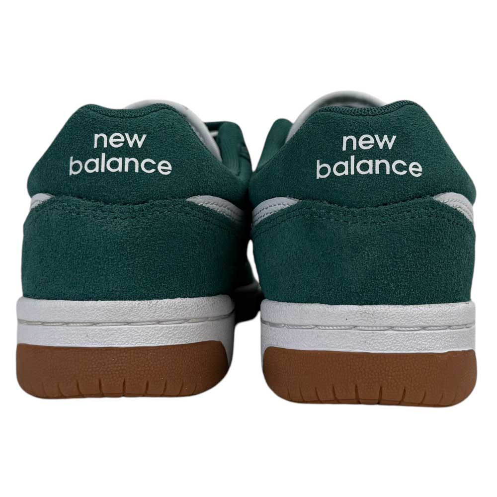 A close-up rear view of green 480 NDI New Balance Numeric Skateboarding Shoes in suede with white midsoles, brown outsoles, and "new balance" printed in white on the back of each shoe.