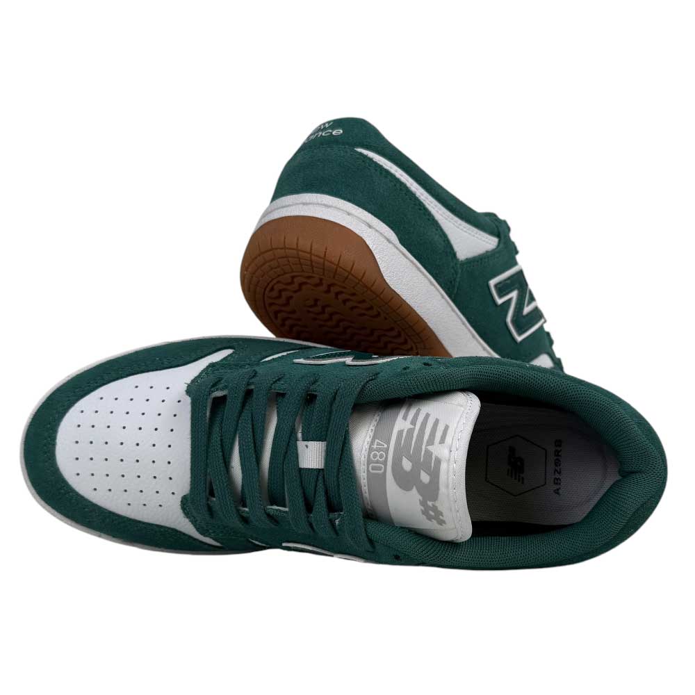 A pair of 480 NDI New Balance Numeric Skateboarding Shoes in suede green and white—one stands upright, the other lies sideways, showcasing the durable upper, gum sole, and perforated toe box.