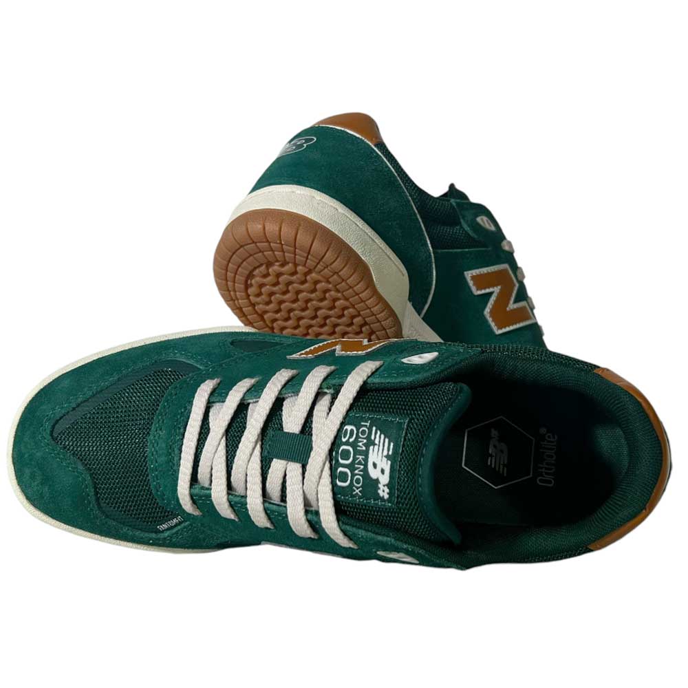 A pair of 600 ALB Tom Knox Green Brown Suede New Balance Numeric Skateboarding Shoes—one shoe upright to show the side and top, the other tilted to display brown tread; classic style, white laces, and built for durability.
