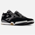 A pair of 770YZZ Black White New Balance Numeric suede skateboarding shoes with white midsoles and gum rubber outsoles, designed for court stability, displayed on a plain white background.