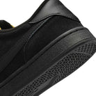 Close-up of the heel and sole of the 909096002 Black Vivid Orange FC Classic Nike SB suede skateboarding shoes, featuring a textured rubber outsole, black suede heel detail, and a comfortable Solarsoft insole.