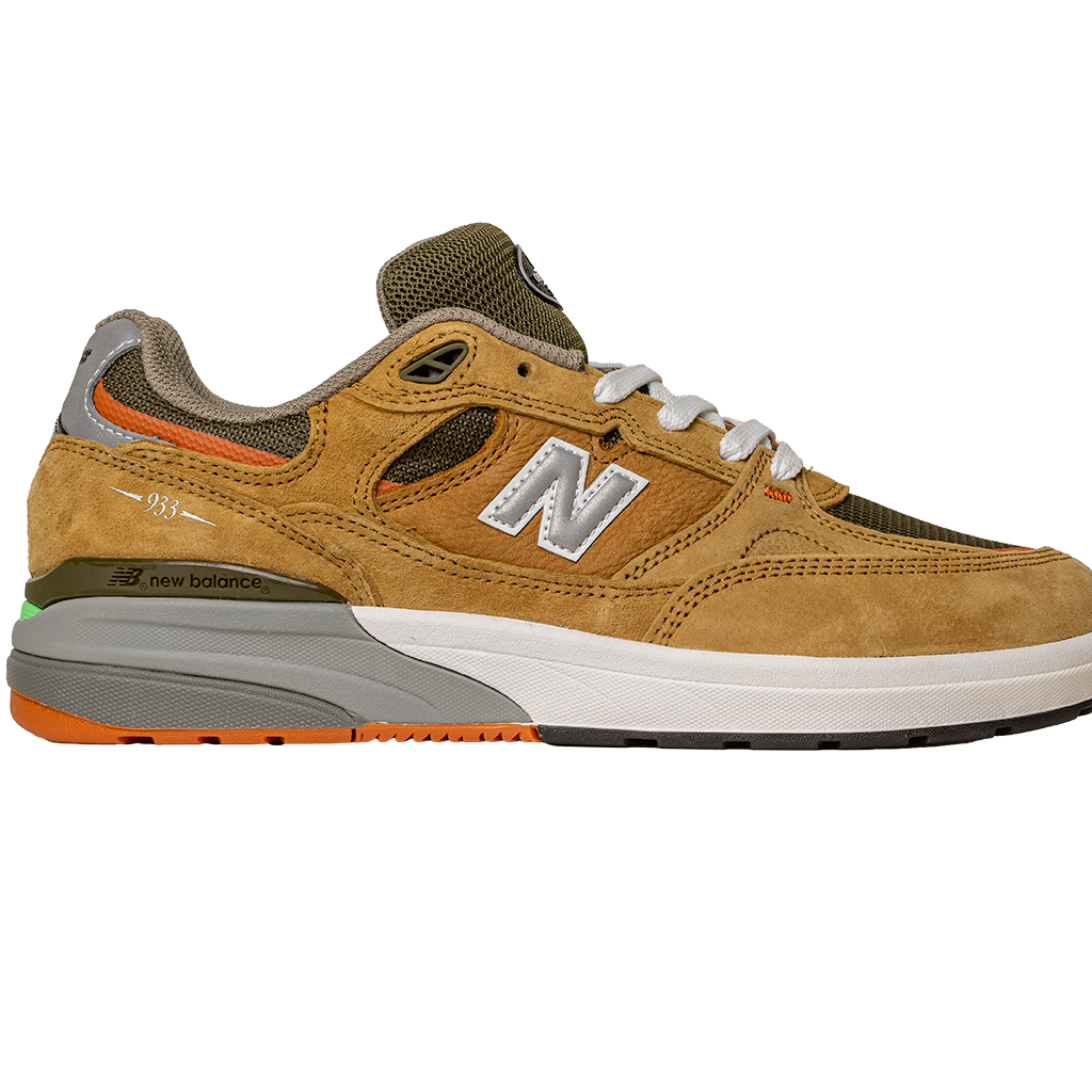The 933 MNO Andrew Reynolds Brown Grey New Balance Numeric Skateboarding Shoes feature mustard yellow suede, olive green mesh, orange accents, a white “N” logo, white laces, and a gray and white sole with green and orange on the heel.