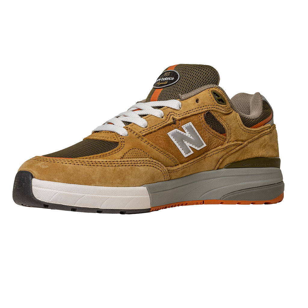 The 933 MNO Andrew Reynolds Brown Grey New Balance Numeric skateboarding shoe features a suede upper, white laces, gray and white sole, and orange accents, shown on a plain white background.