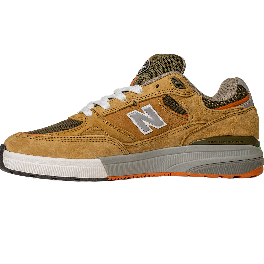 The 933 MNO Andrew Reynolds Brown Grey New Balance Numeric Skateboarding Shoes Suede, featuring a tan and brown design with a white N logo, white laces, and orange-accented sole, is displayed on a white background.