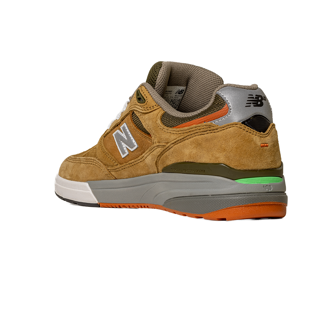 The 933 MNO Andrew Reynolds Brown Grey New Balance Numeric Skateboarding Shoe features tan suede, a white N logo, grey heel, green midsole accent, orange outsole, and white toe. Displayed angled on a plain white background.