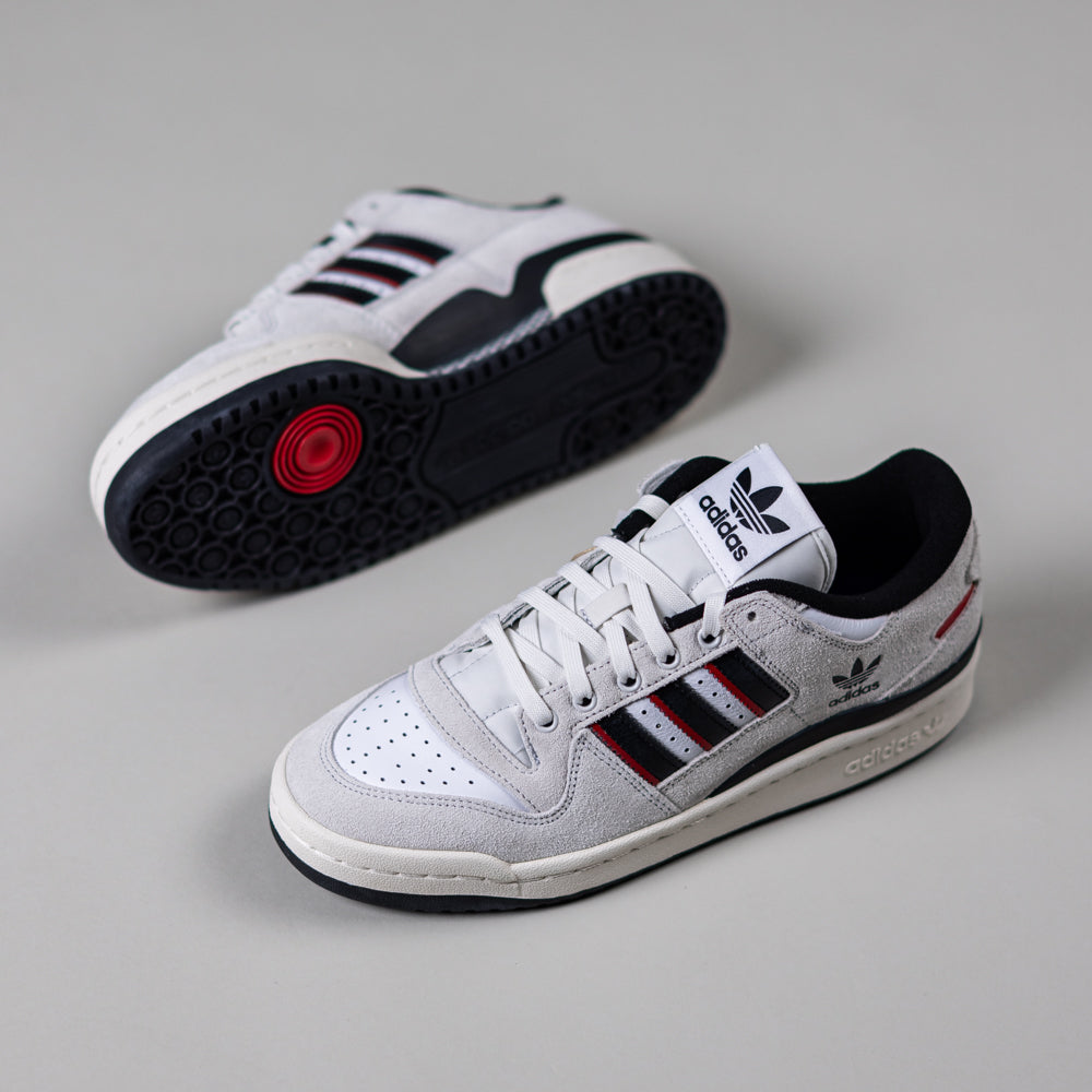 The JP6094 Cry White Core Black Forum 84 Low Adidas Skateboarding Suede Shoes feature signature three stripes, black and red accents, suede details, and Adidas branding on the tongue and heel; one shoe stands upright, the other reveals the sole.