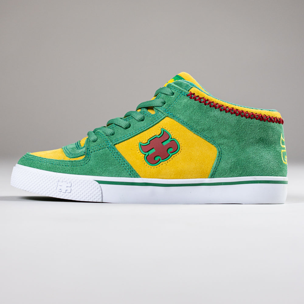 The Kenny Reed Mid Vulc Green Yellow Suede I Path Skateboarding Shoes feature red stitching, a puzzle piece logo, and a white sole—ideal for fans of the Kenny Reed style. Displayed on a plain gray background.