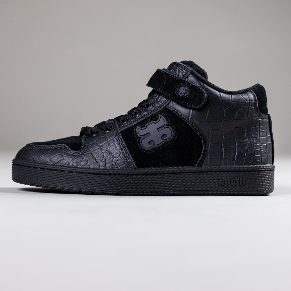 The Grasshopper Black Croc Leather I Path Shoes combine a textured crocodile pattern, velcro strap, rubber sole, side logo, and embossed Sumi branding for stylish skateboarding footwear.