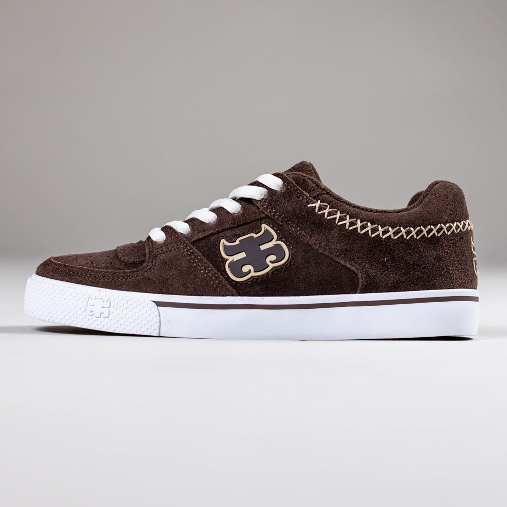 The Kenny Reed Low Vulc Brown Suede I Path Skateboarding Shoe features white laces, a white sole, beige stitching, and a beige side logo, shown against a plain grey background.
