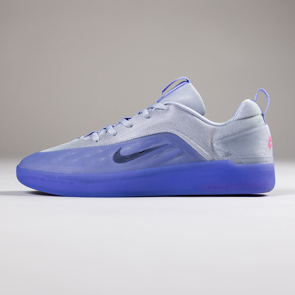 The FQ1273500 Light Thistle Black Zoom Nyjah 4 Nike SB Skateboarding Shoes feature Air Zoom cushioning, a reinforced mesh upper, dark Nike swoosh, and translucent blue sole, shown against a plain, light background.