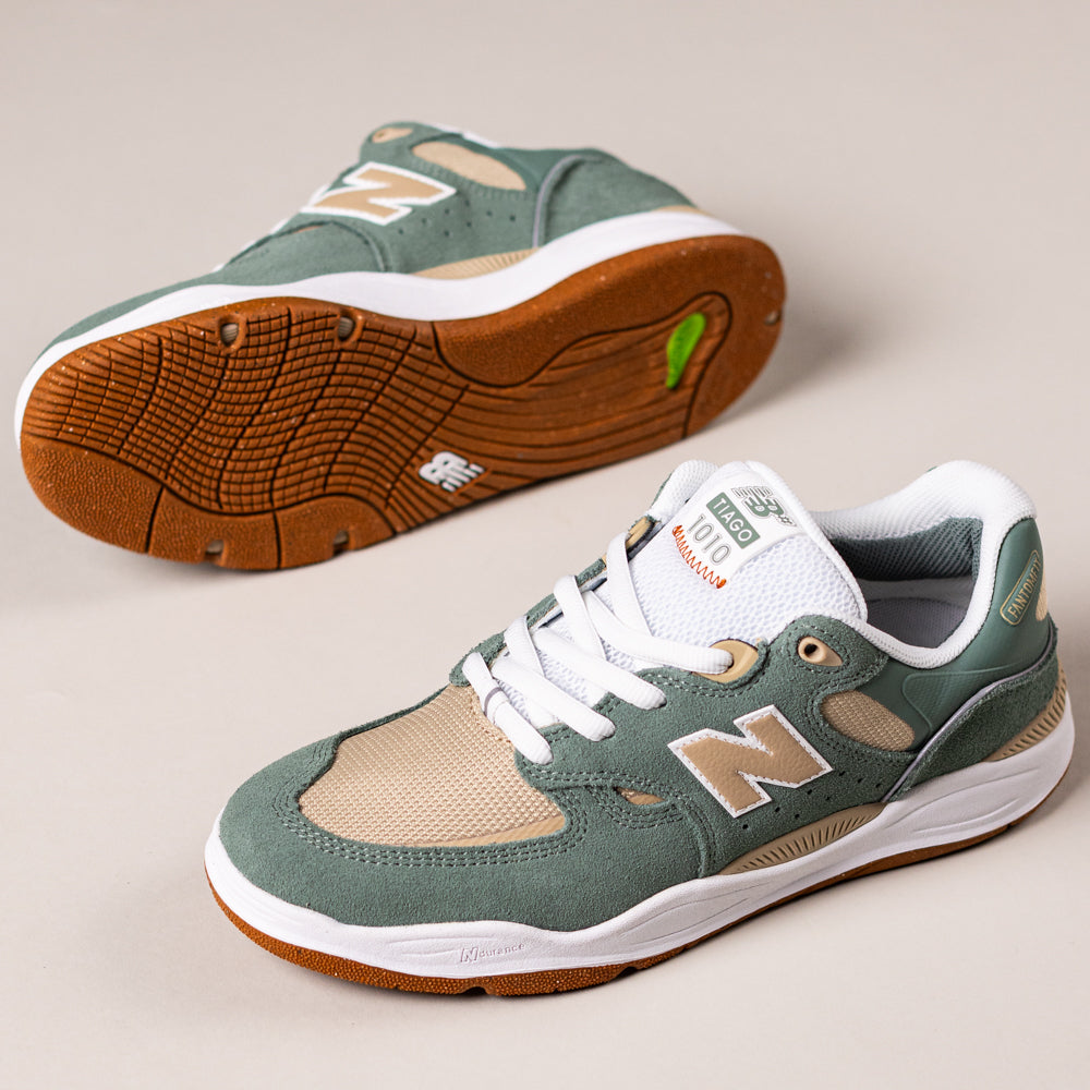 The 1010TC Dark Juniper Sandstone Tiago Lemos New Balance Numeric Suede Skateboarding Shoes feature green, beige, and white panels, white laces, and gum rubber soles. One shoe stands upright; the other displays the sole's grip and durability.