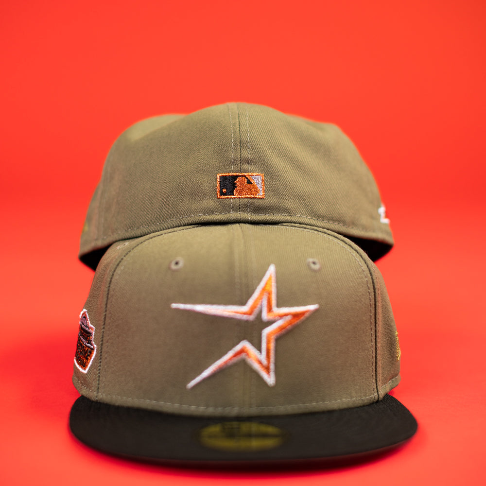 Two The Original Olive Black CC Astros New Era Hat 5950 Fitted caps with black brims are shown on a red background. One displays a bold white and orange star logo; the other shows a small MLB logo. Perfect for CC Astros fans.