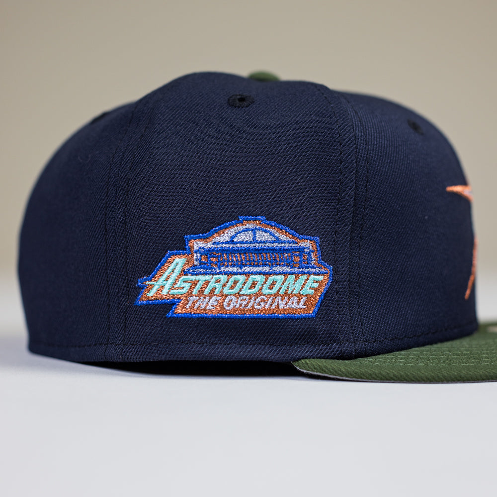 The Aquamarine Navy Rifle Green Astros New Era Hat 5950 Fitted features an embroidered stadium patch and “Astrodome The Original” in blue, orange, and white on the side, with a green brim adding a fresh touch.