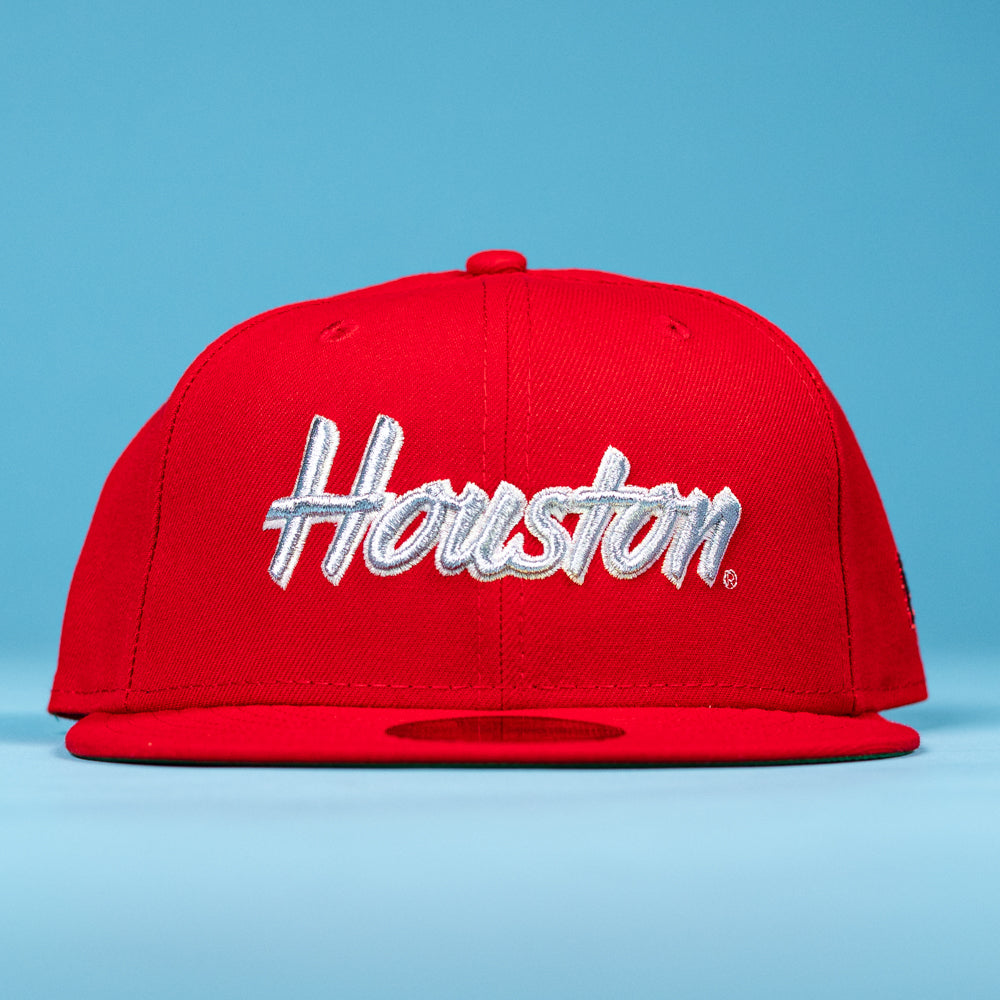 A Cougar Scarlet Houston Cougars New Era 5950 Fitted Hat, featuring "Houston" in white script on the front, is showcased against a light blue background.
