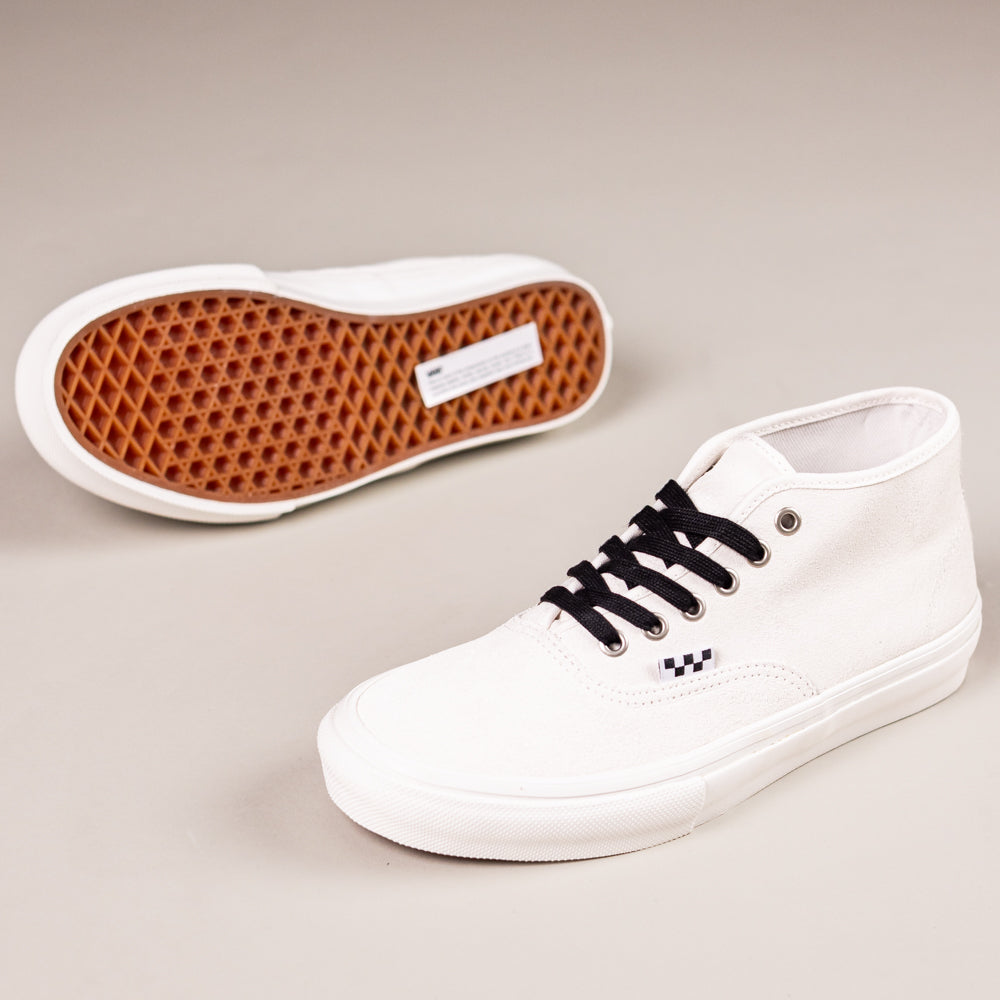The VN000EJSJVY Blanc de Blanc Authentic Mid Vans Skate Suede Shoes, featuring white canvas, black laces, checkerboard accents, and waffle outsole, are displayed with one upright and the other on its side against a light background.