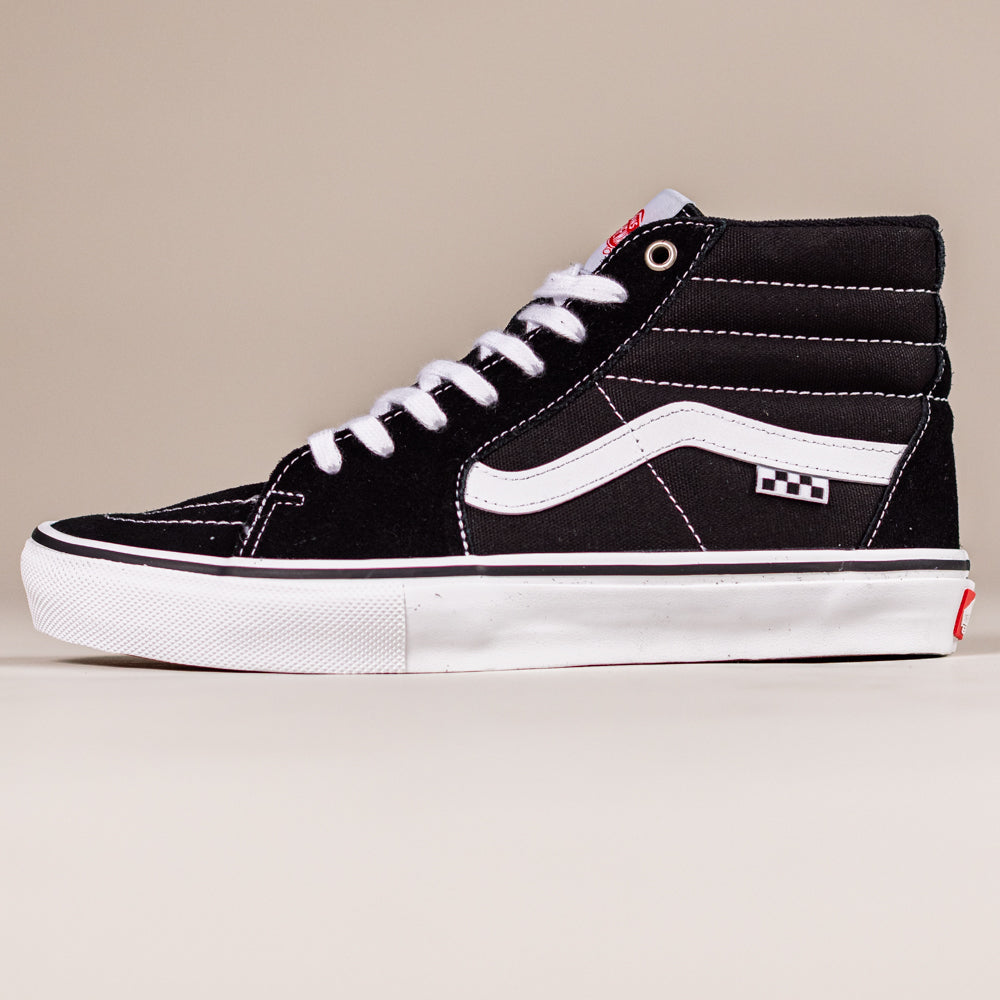 The VN0A5FCCY281 Black White Skate SK8-HI Suede Vans Shoes feature black suede uppers, white laces, a white sole, and the iconic white side stripe, shown against a plain beige background.