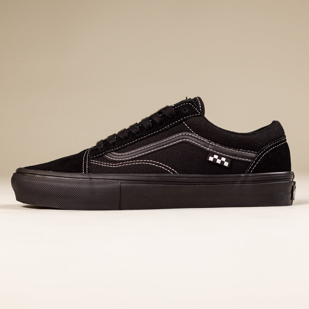 The VN000EJ3174 Black Black Grey Skate Old Skool Vans Suede Skateboarding Shoes feature a black low-top design with white stitching, signature wavy side stripe, and flat rubber sole, captured on a beige background—classic skate style inspired by skate legends.