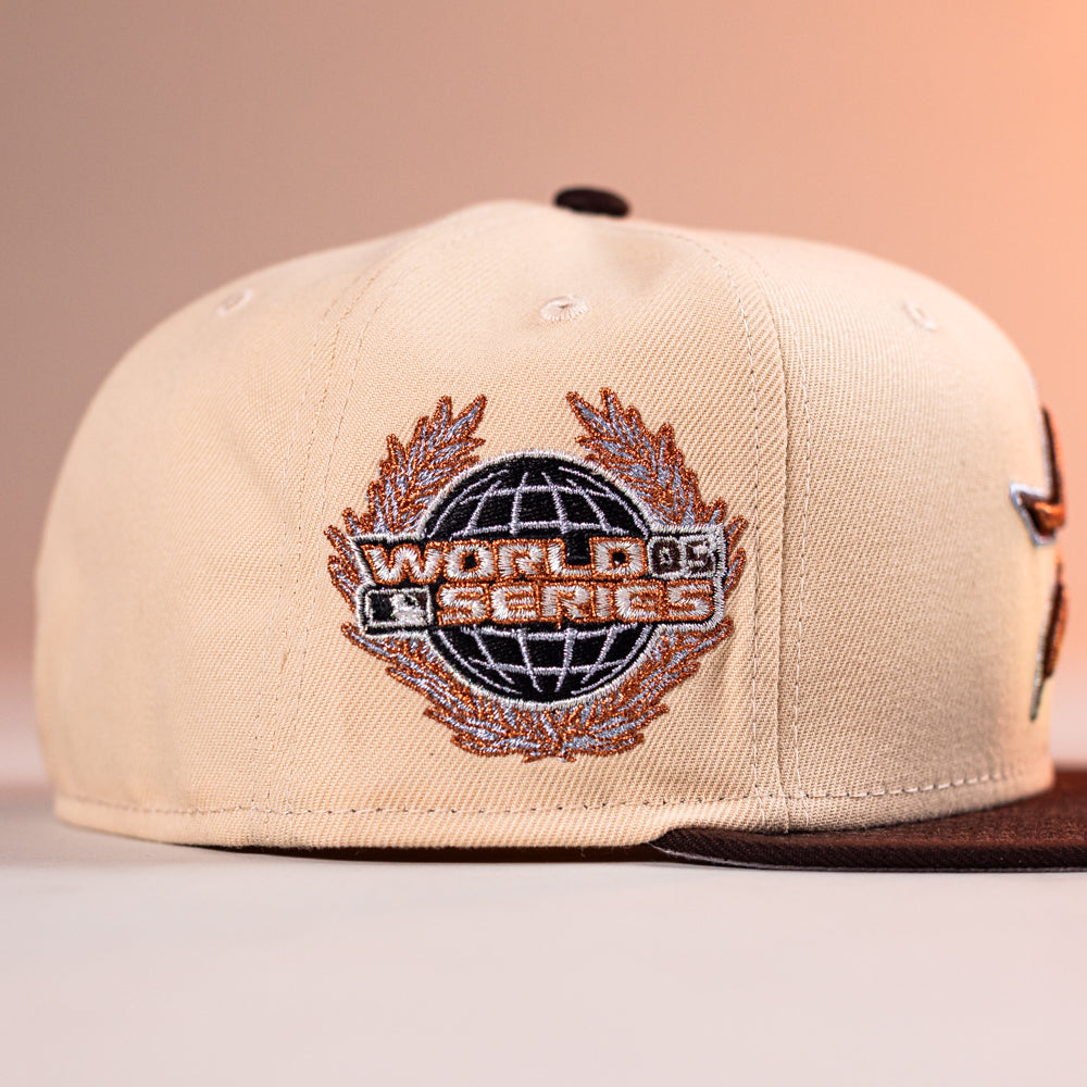 The Flat White WS05 Mango Wood Astros New Era 5950 Fitted Hat features an embroidered World Series logo on the side, highlighted with orange and black stitching, blending classic design with collectible appeal.