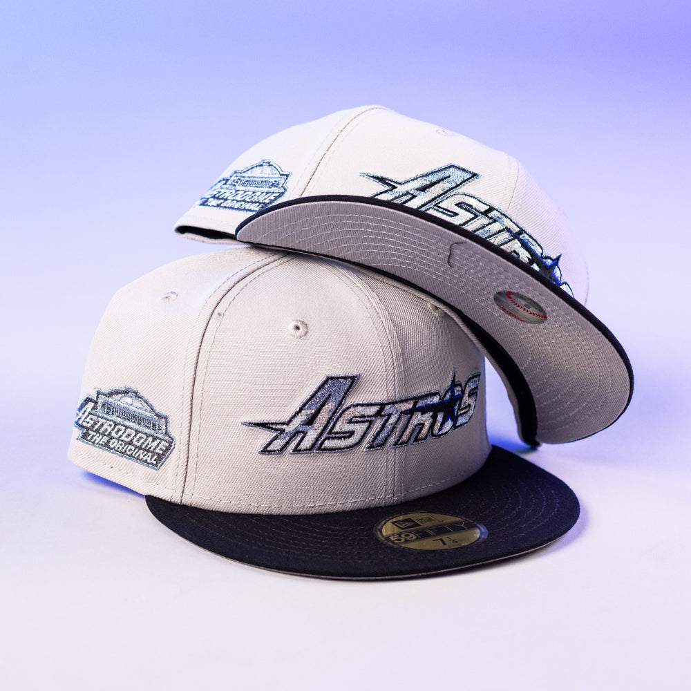 Two SNOFALL Blue Camo Houston Astros New Era 5950 Fitted hats, showcasing Astros and Astrodome The Original logos, are stacked on a light purple background—one upright, one on its brim—perfect for Blue Camo Houston Astros style.