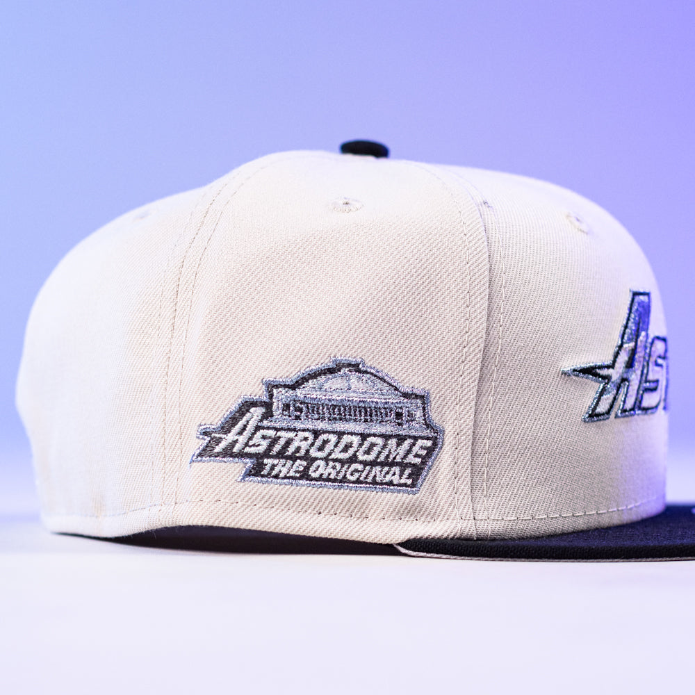 The SNOFALL Blue Camo Houston Astros New Era Hat 5950 Fitted features a white and black design with an embroidered Astrodome logo and "Astrodome The Original" on the side, set against a purple-tinted background.