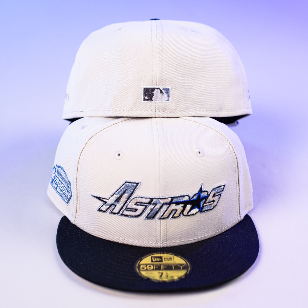 Two SNOFALL Blue Camo Houston Astros New Era 5950 Fitted caps are shown on a light purple background. The front cap features the Astros logo and side patch; the rear displays the MLB logo on blue camo detailing.