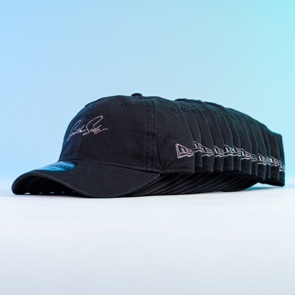 A row of Southside Pewter Script Strapback 920 Hat New Era caps is neatly arranged on a white surface with a blue gradient background, each featuring white embroidered text on the front and side.