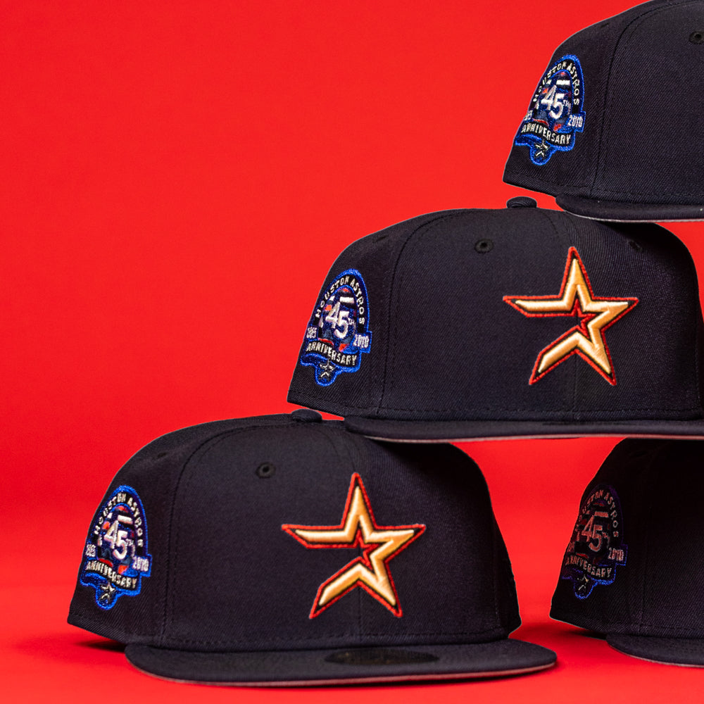 Three black New Era 5950 Fitted caps with orange star logos and blue 45th Anniversary patches are stacked against a red background, echoing the design of the 6am in Texas Navy Red White New Era Hat 5950 Fitted.