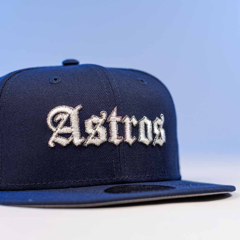 The Fat Elvis OE ASG Dark Blue New Era Hat 5950 Fitted features "Astros" in white old English-style embroidery on a light blue front panel.