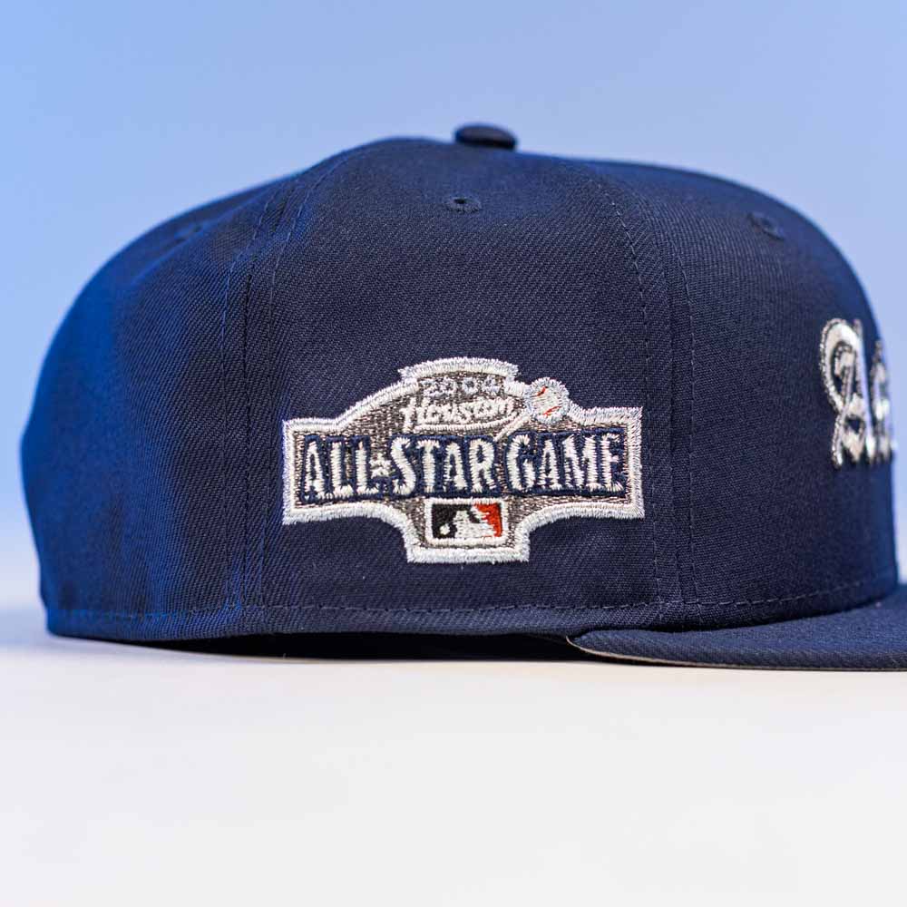 The Fat Elvis OE ASG Dark Blue New Era Hat 5950 Fitted features a flat brim, a dark blue crown with light blue background, and the embroidered 2023 MLB All-Star Game logo on the side.