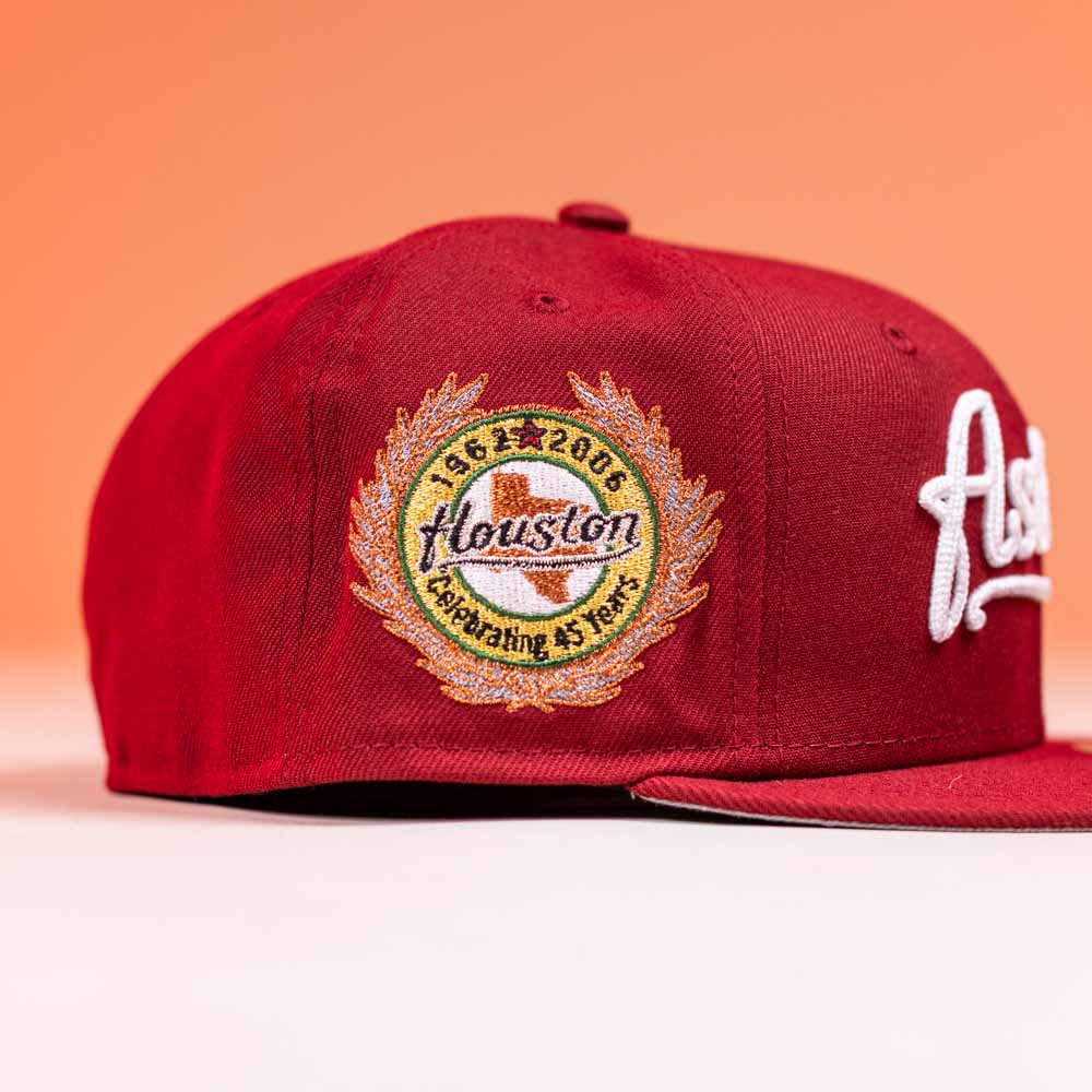 The Big Puma Cardinal White Script New Era Hat 5950 Fitted by New Era, in red with commemorative “1965-2006 Celebrating 45 Years” side patch, is displayed on an orange background.