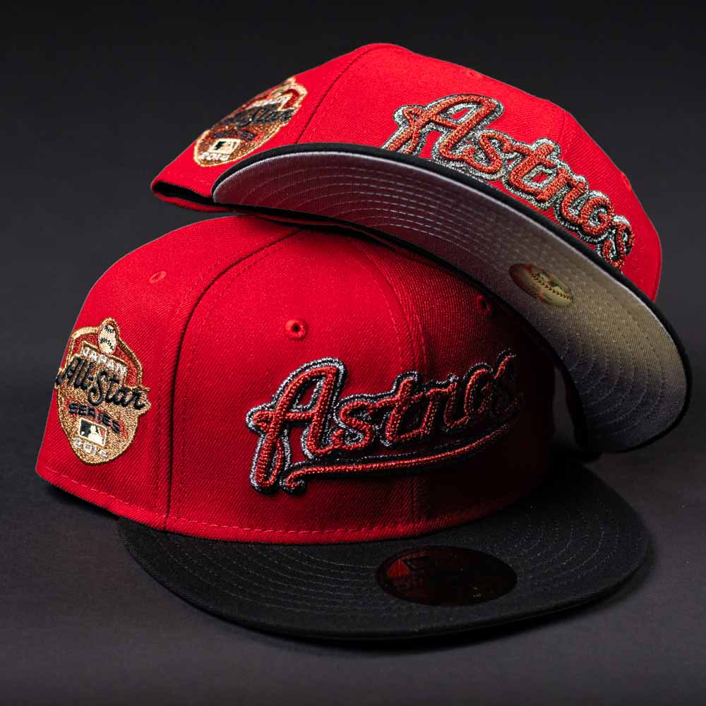 Two Samurai Japan ASG Houston Astros New Era 5950 Fitted hats in red and black are displayed on a dark background, with "Astros" embroidered on the front and a 2022 All-Star Game patch on the side.