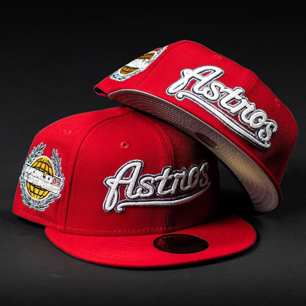 Two red Sunnyside Bo Bundy WS05 Houston Astros New Era 5950 fitted hats with white embroidered logos and a globe side patch are shown on a dark background. One cap stands upright, the other lies atop it, underside brim visible.