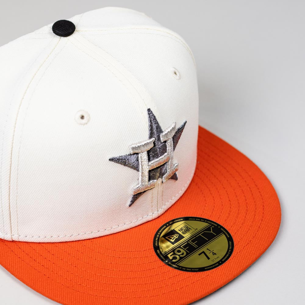 The Orange Soda New Era WS22 Houston Astros 5950 Fitted Hat is white with an orange brim, featuring a silver and black embroidered Astros star logo on the front and a gold size 7 1/4 sticker on the brim.