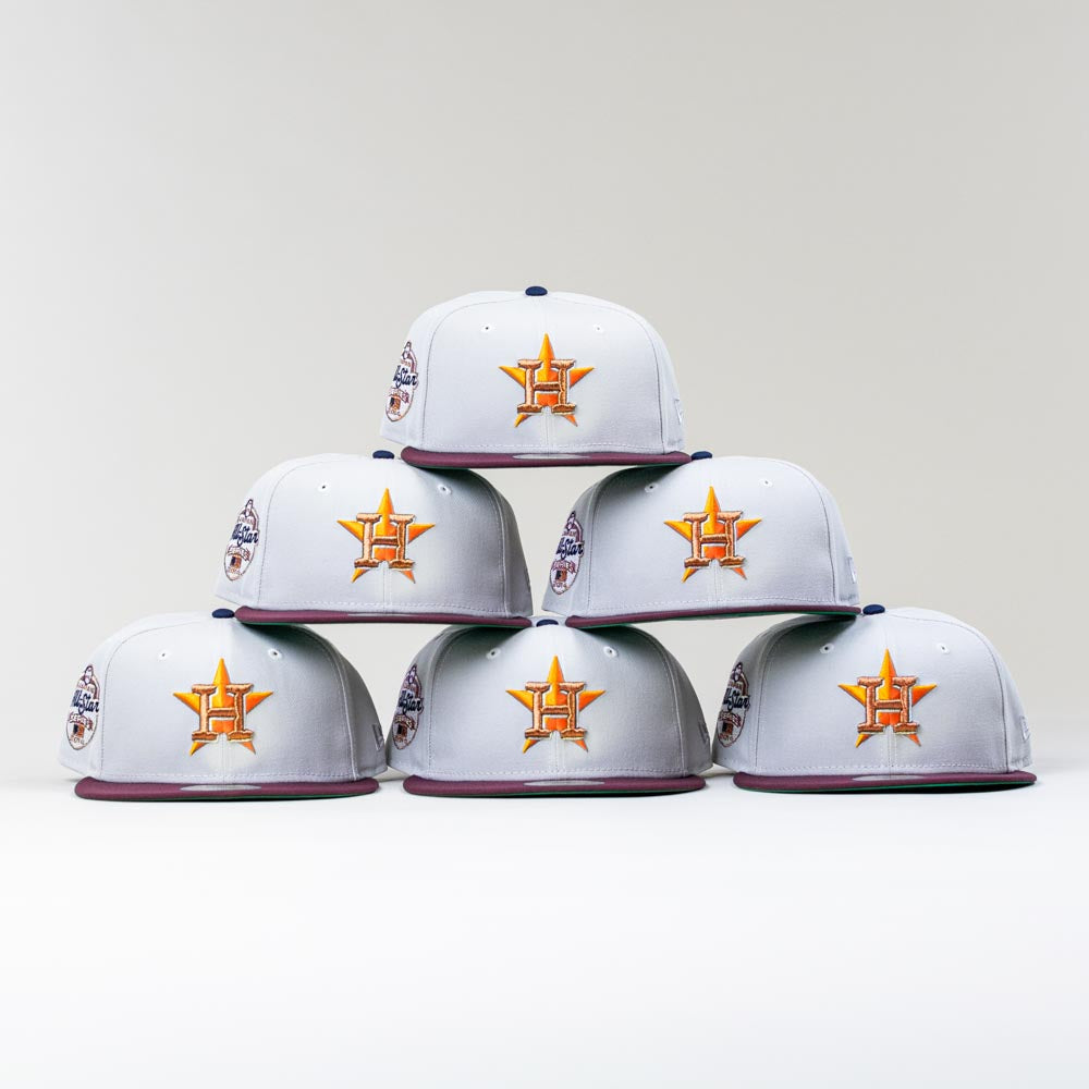 Six Shibuya Lights New Era Silver Japan Houston Astros 5950 Fitted hats are arranged in a pyramid on a white background, showcasing the Astros logo on the front and a commemorative patch on the side.