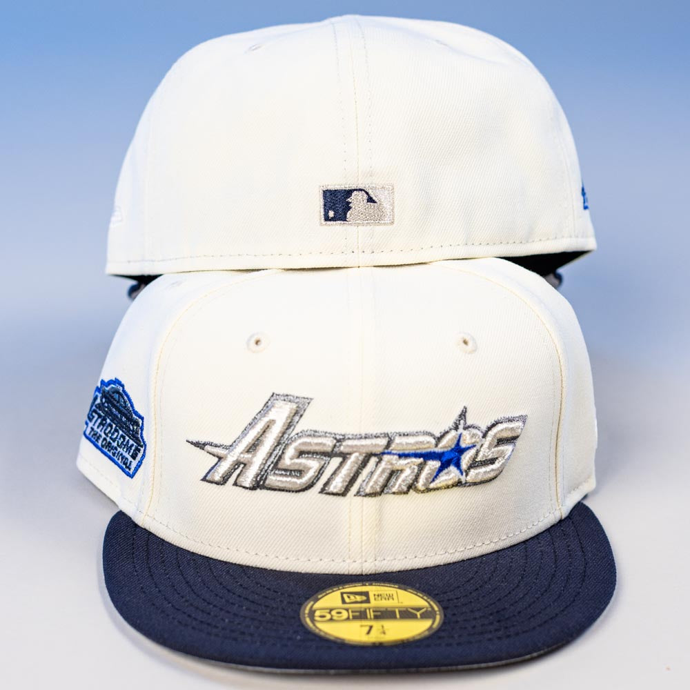 Two cream-colored International Flea Bo Bundy New Era Houston Astros 5950 Fitted hats with navy brims; front cap has the Astros logo, star, side patch, and 59FIFTY sticker; back cap shows a small MLB logo.