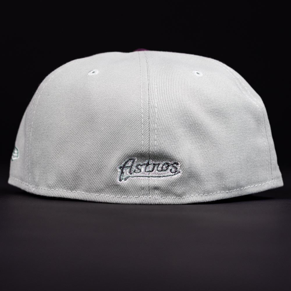 The Pixie Dust New 2000 Houston Astros New Era 5950 Fitted cap, shown from the back, displays "Astros" embroidered in silver on the bottom center against a black background.