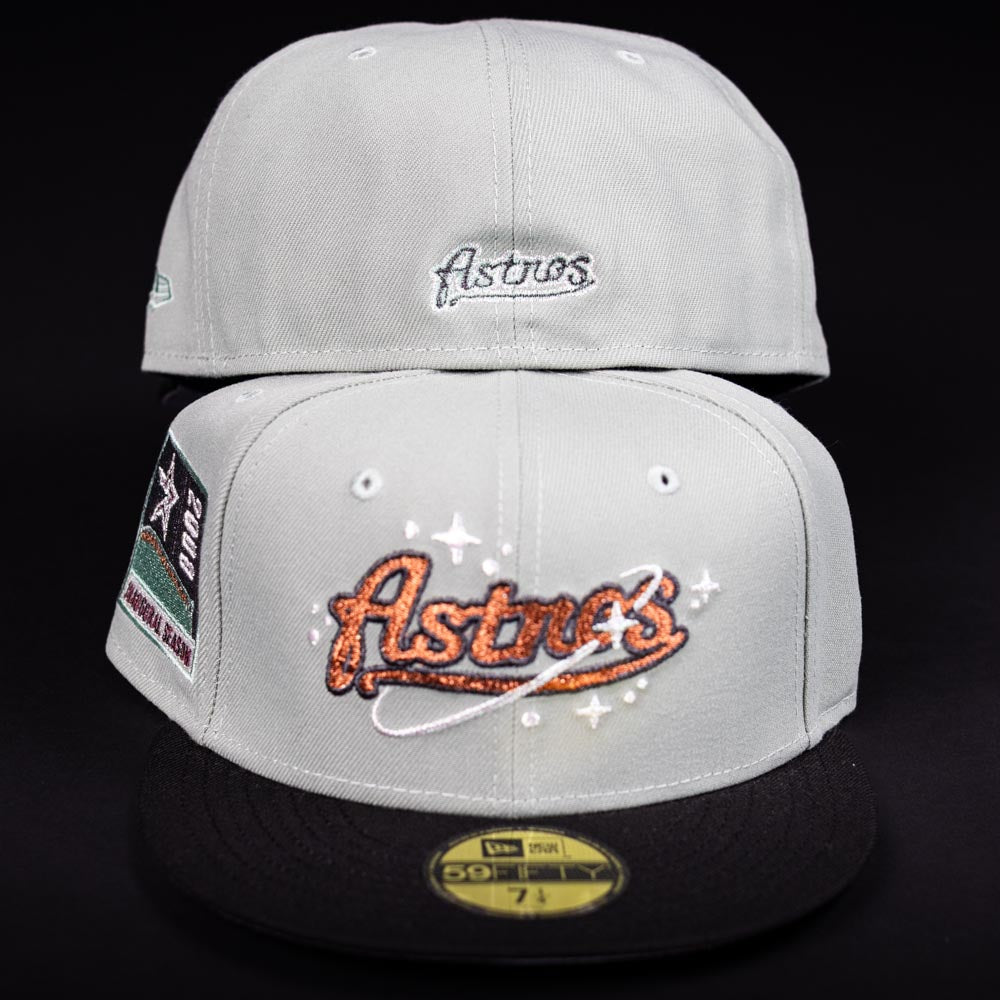 Two light grey Pixie Dust New 2000 Houston Astros New Era 5950 Fitted caps with black brims are shown. The front features a sparkly Astros logo, while the back displays smaller embroidered Astros text. Both are authentic New Era hats.
