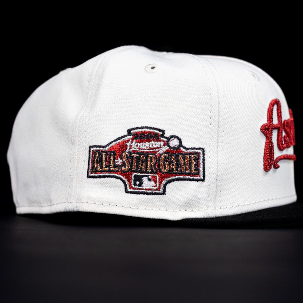 The Red Soda New Era HOF Red Black Chrome Houston Astros 5950 Fitted Hat features a red and black embroidered patch with "Houston All-Star Game," the MLB logo on the side, and stands out with its sleek black design.